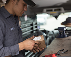 Generator Supercenter technician in a garage opening a box
