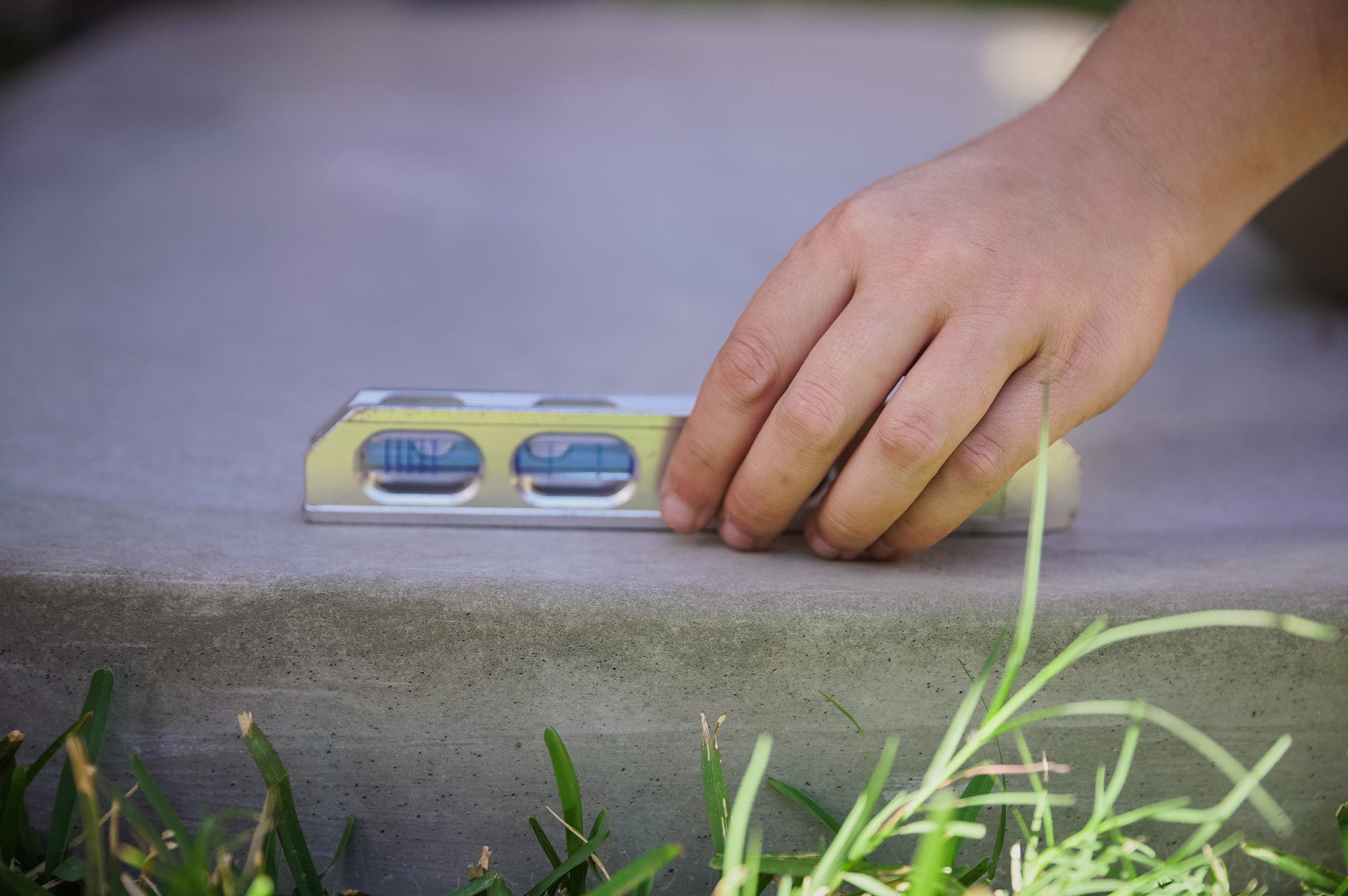 man checking concrete pad level