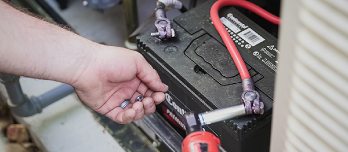 man's hand adjusting large battery