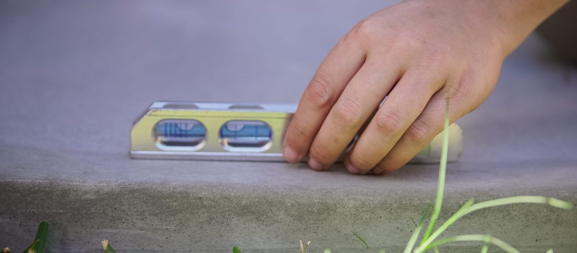 man checking concrete pad level